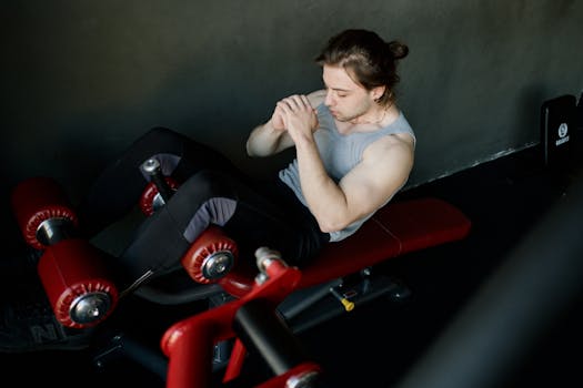 A focused man performs abdominal exercises on gym equipment, highlighting fitness and determination.