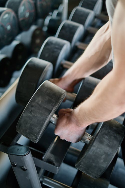 Free Person Taking Dumbbells from a Rack Stock Photo