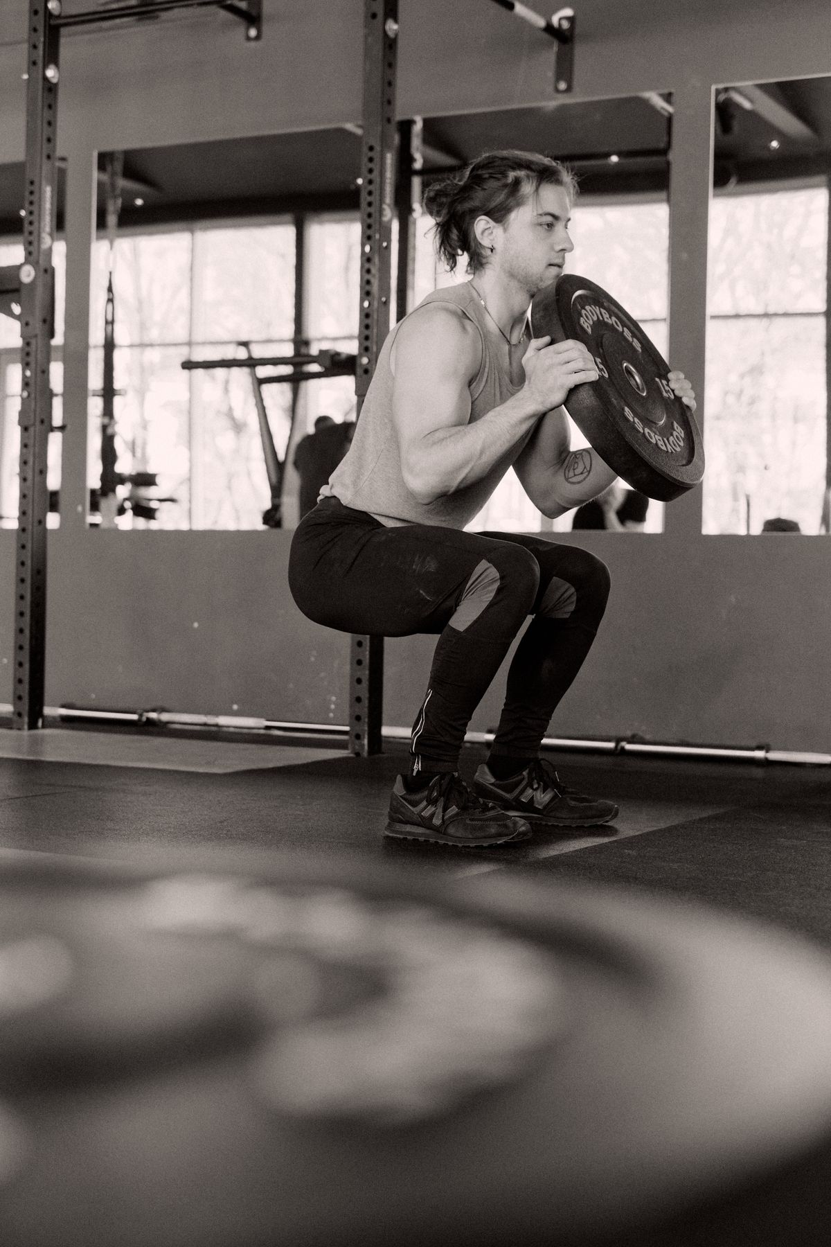 Man doing squats during an AMRAP workout session at the gym