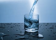 这张高质量图像展示了水倒入玻璃杯的过程，说明了水合作用和纯度