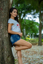 Carefree adolescent smiling while standing near tree