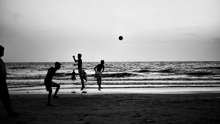 Grayscale Photo Of Boys Playing At The Beach