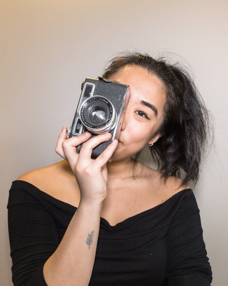 Ethnic Hipster Woman With Photo Camera Near Wall At Home