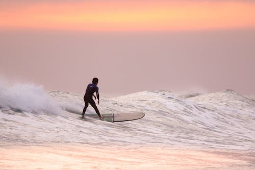 Ücretsiz Altın Saatte Sörf Yapan Adam Stok Fotoğraflar