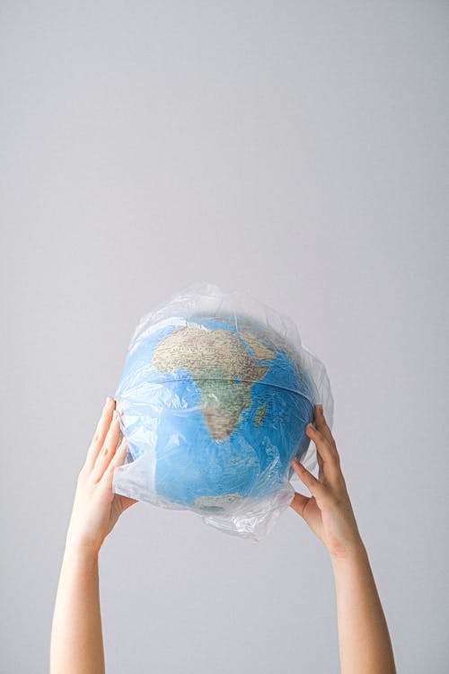 Free A Person Holding a Globe in a Plastic Bag Stock Photo