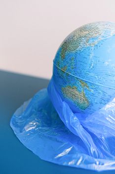 地球仪被塑料袋覆盖，象征着环境污染和全球变暖