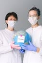 两名医护人员举着一个象征全球健康危机的“流行病”地球仪