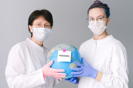 Two healthcare professionals in masks hold a globe labeled 'Pandemic,' symbolizing global healthcare crisis.