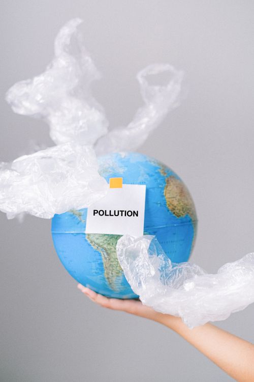 Free A globe wrapped in plastic symbolizes pollution and environmental concerns. Stock Photo