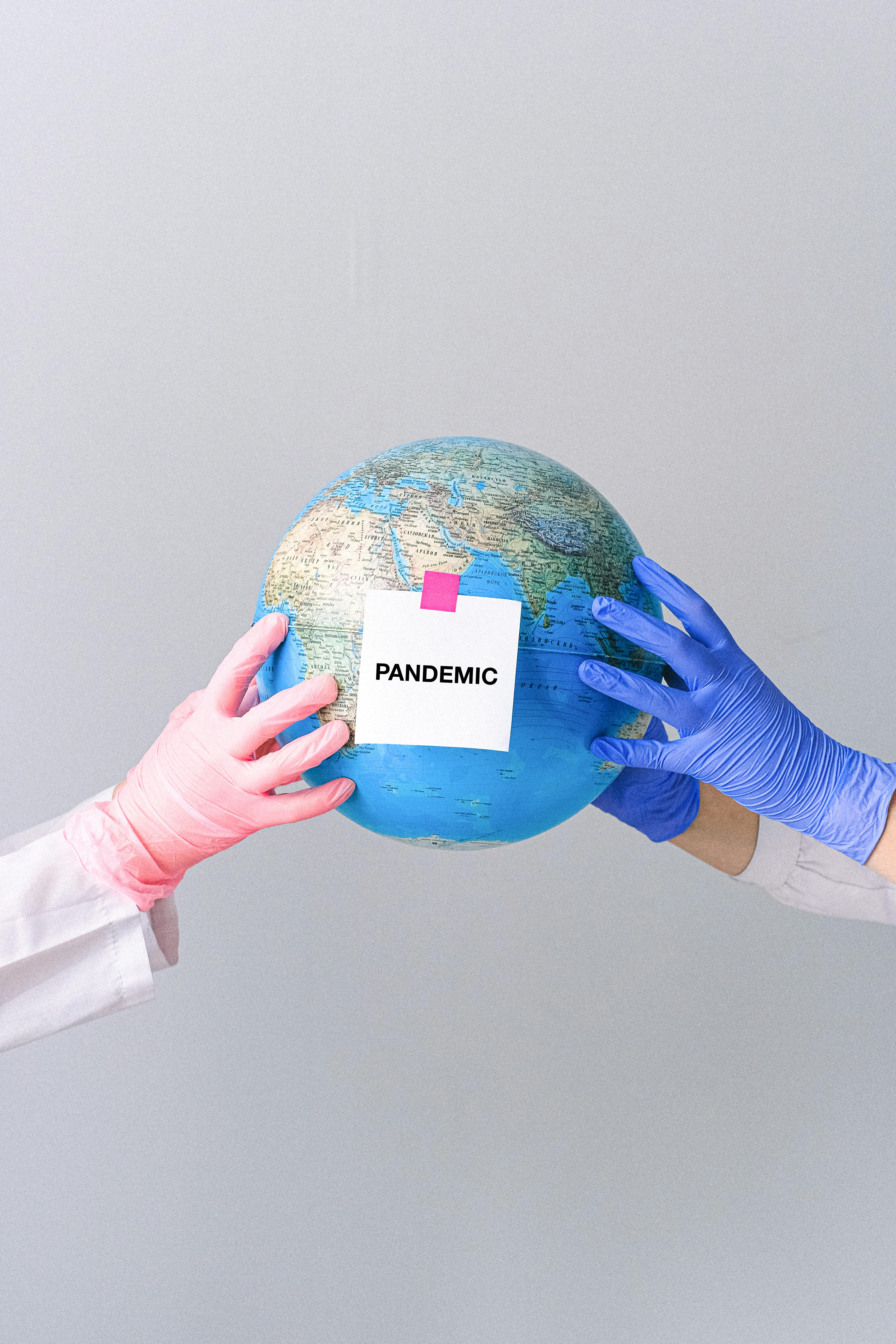 hands with latex gloves holding a globe