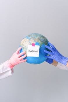 Gloved hands holding a globe with 'Pandemic' text, symbolizing global health crisis.