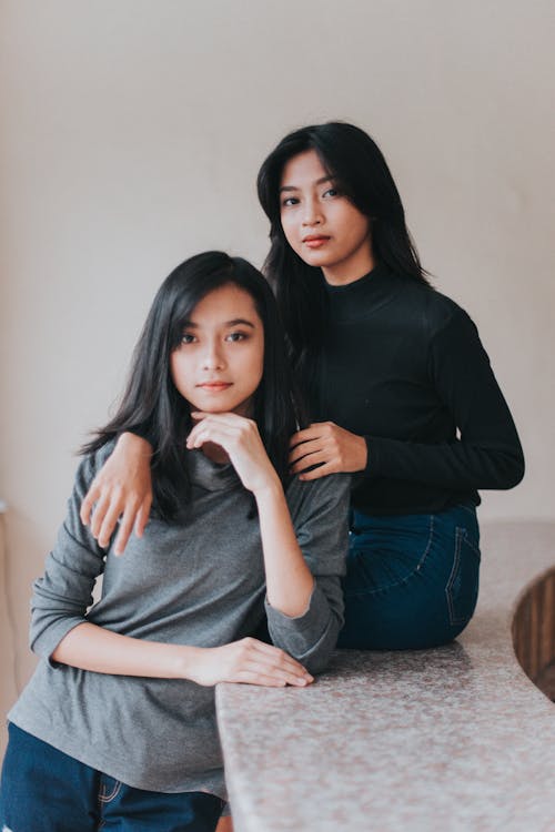 Mulher De Camisa Preta De Manga Comprida E Jeans Azul, Sentada No Chão