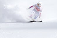 在冬季体育赛事中，一名滑雪者在雪坡上快速精准地滑行