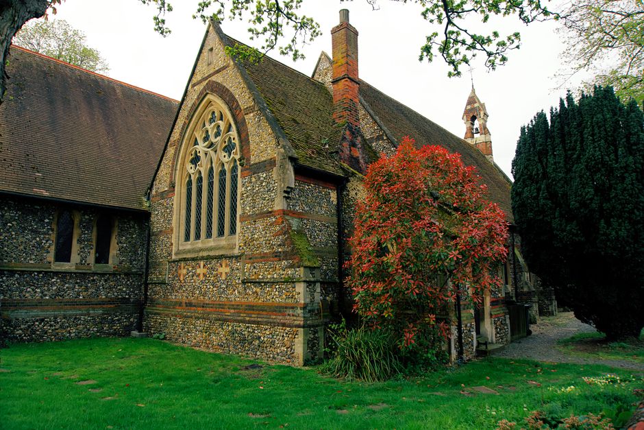 A picturesque stone church with Gothic architecture and lush surroundings in the United Kingdom.