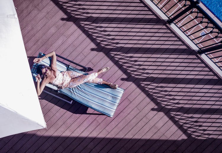 Unrecognizable Tourist Resting On Lounger On Hotel Terrace During Vacation