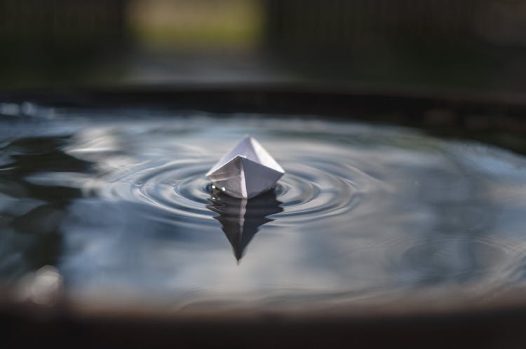 White Paper Boat On Floating On Water