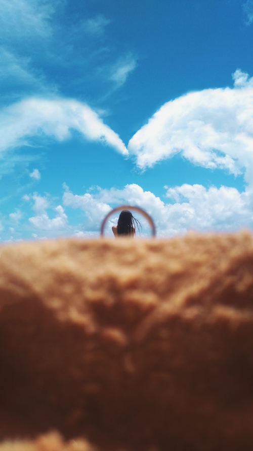 Free Silhouette of a woman gazing at a bright sky with fluffy clouds. Captures a moment of tranquility and wonder. Stock Photo