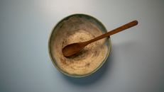 Bowl with wooden spoon on white table