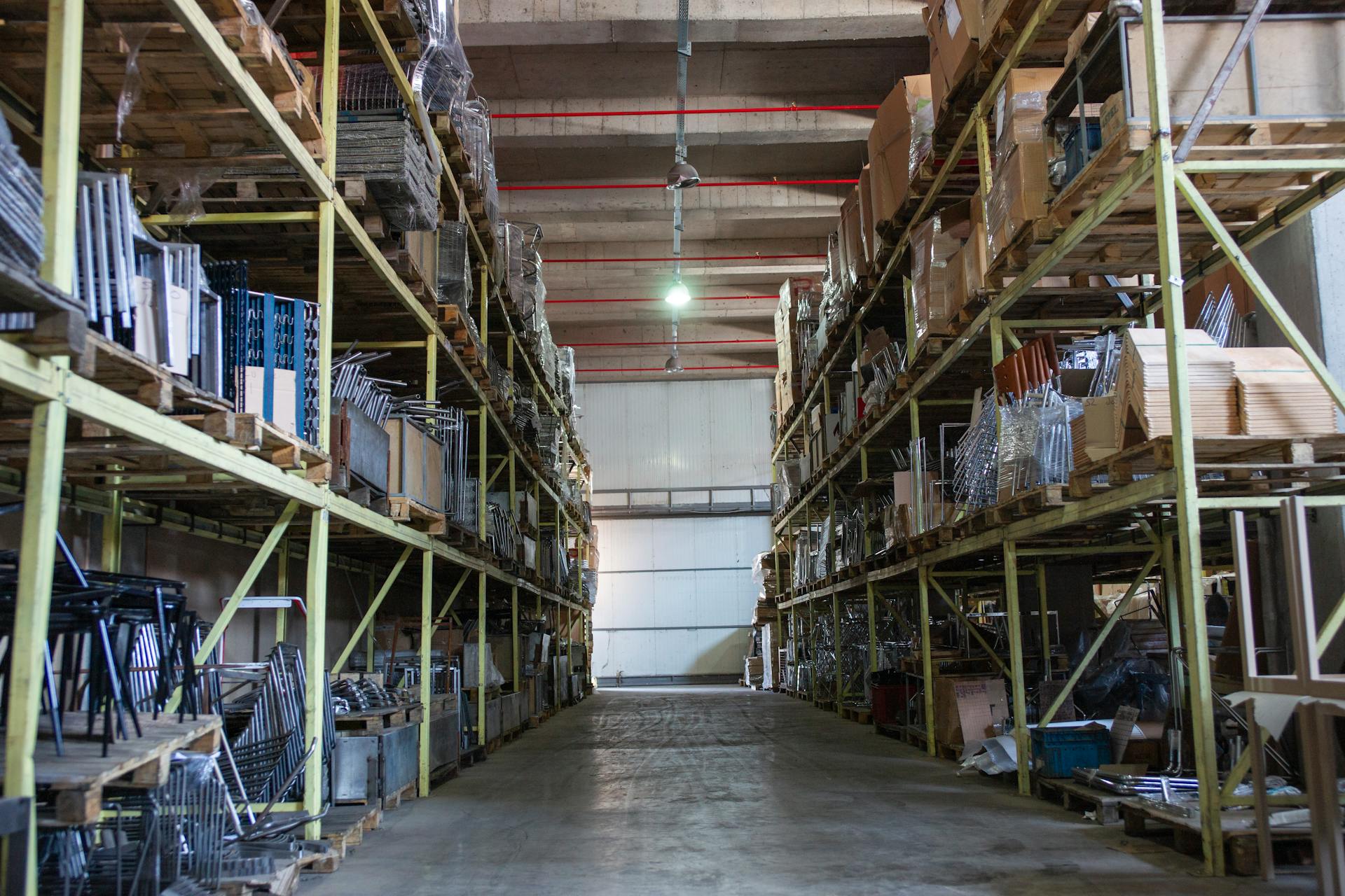 Wide aisle in a spacious warehouse filled with industrial metal shelving units.