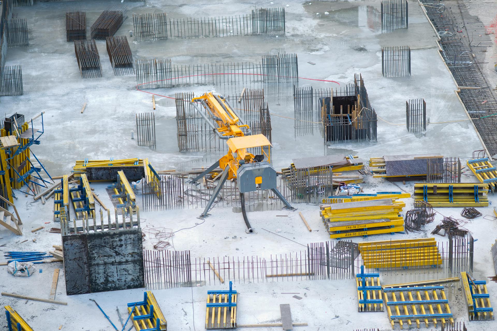 Aerial view of an active construction site with heavy machinery and building materials.