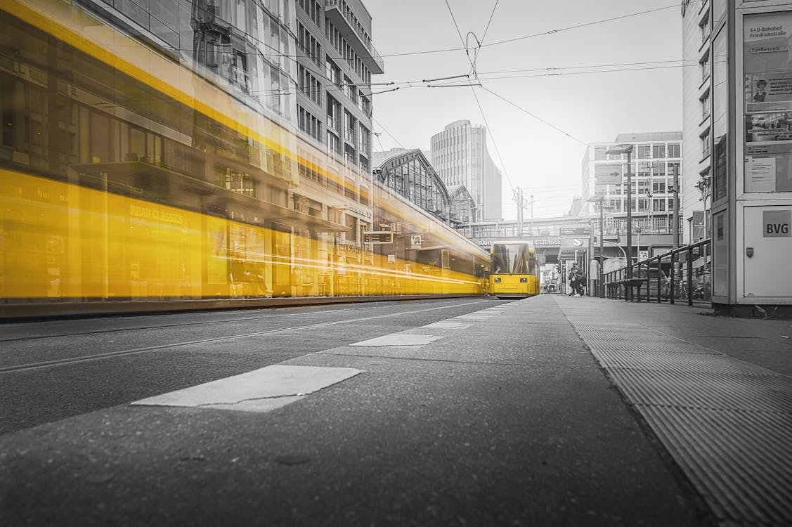 Selective Color Photography of Yellow Train Beside Building