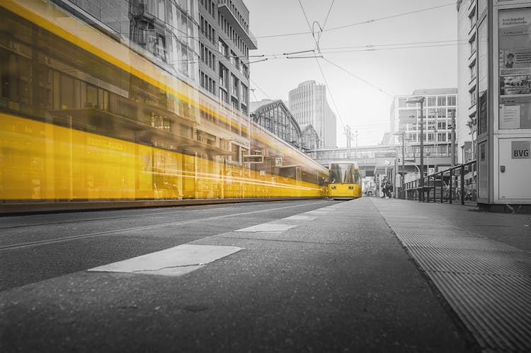 Selective Color Photography Of Yellow Train Beside Building