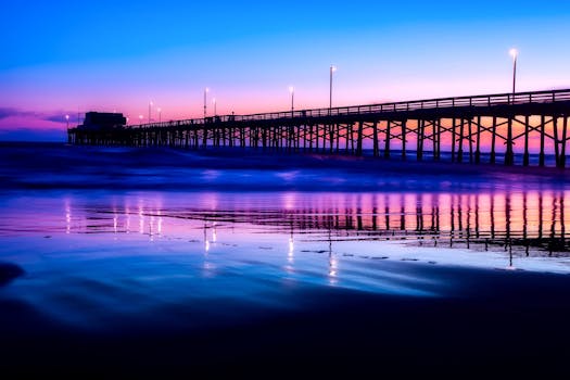 黄昏时分，码头的明亮灯光倒映在大海上，营造出宁静的海景