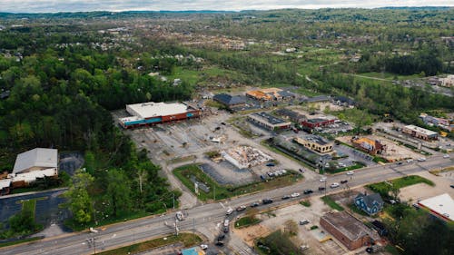 Aerial view of small town outpost area with low level commerce buildings surrounded with lush green trees