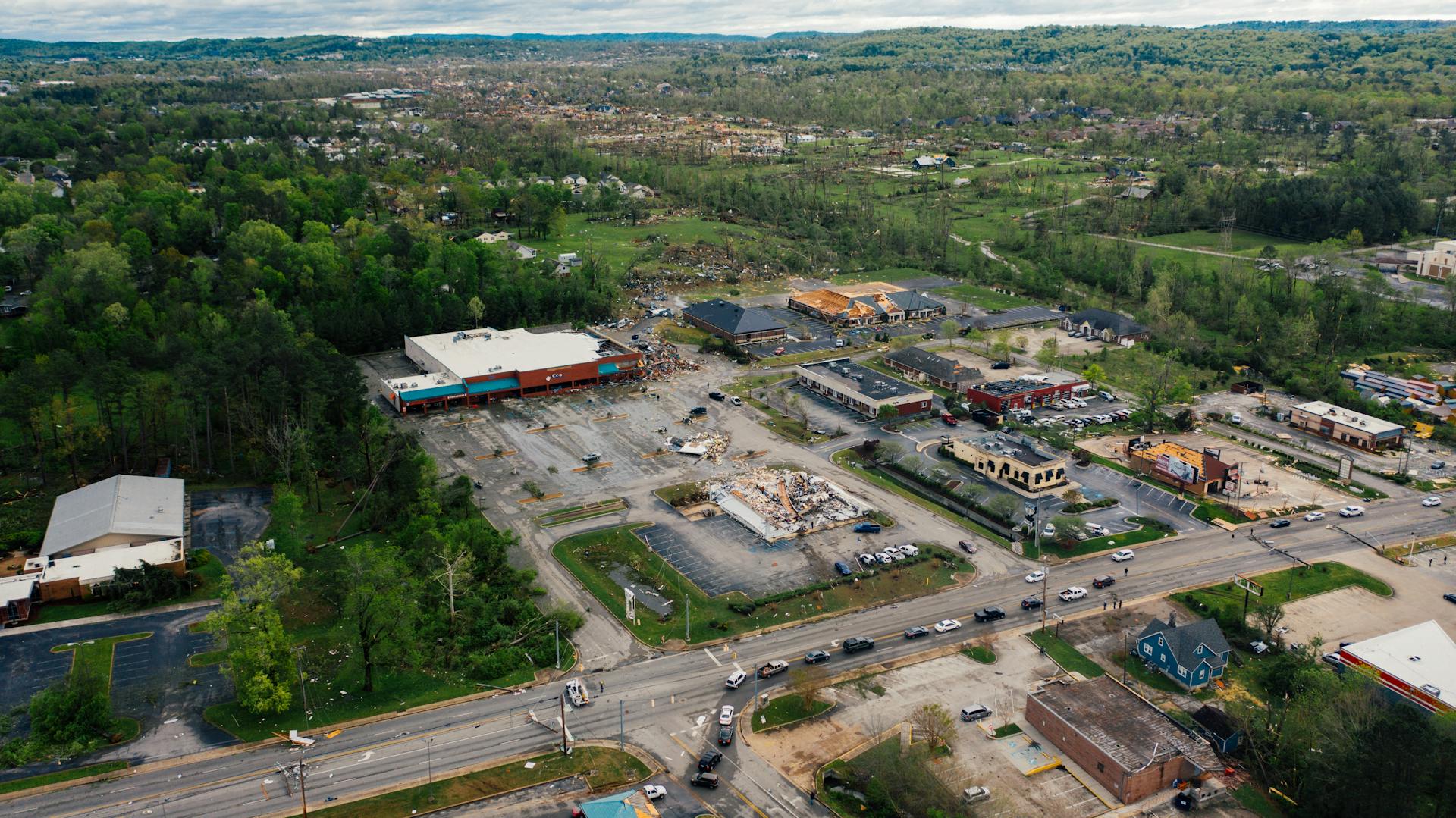 Aerial view of small town outpost area with low level commerce buildings surrounded with lush green trees
