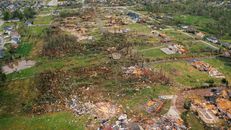 Destroyed village cottages and uprooted trees after tornado