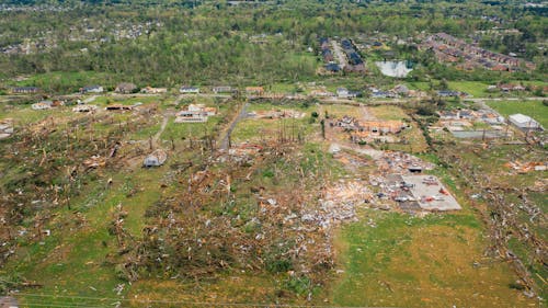 Drone view dramatic impact of massive hurricane on small village with destroyed cottages and uprooted trees