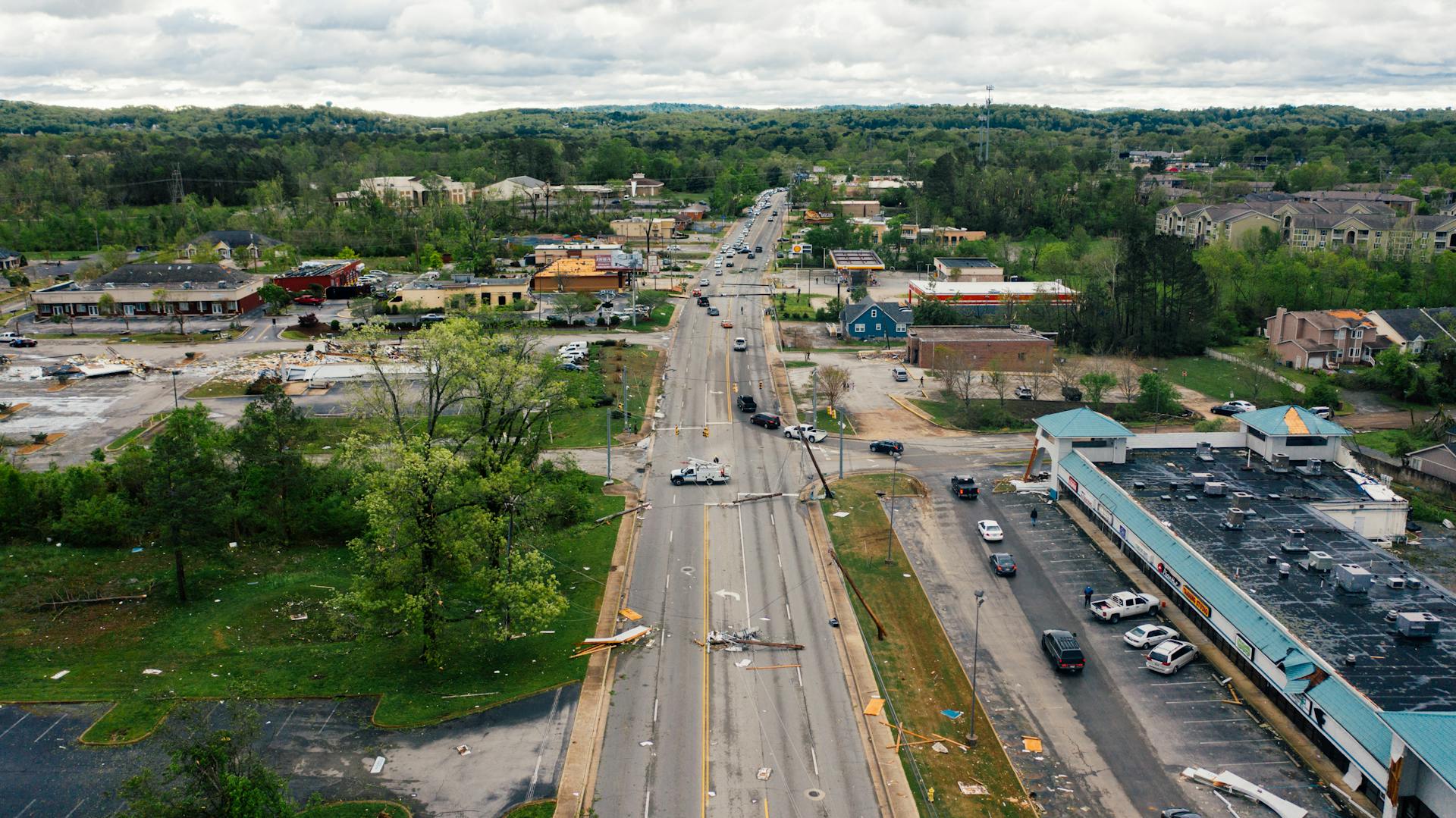 Aerial view of a damaged urban street with minimal traffic, highlighting storm aftermath in Chattanooga, TN.