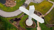 一张宁静的航拍照片，展现了田纳西州查塔努加一座被郁郁葱葱的绿色植物包围的大型十字纪念碑