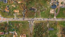 Aerial view of village houses ruined by wild storm near windthrown trees and electricity lines