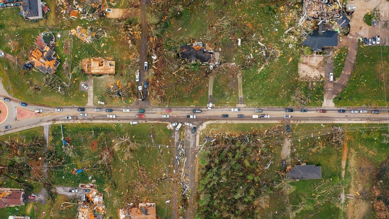 Aerial view of village houses ruined by wild storm near windthrown trees and electricity lines