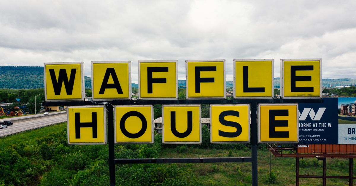 Waffle House sign with scenic mountain backdrop in Chattanooga, Tennessee.