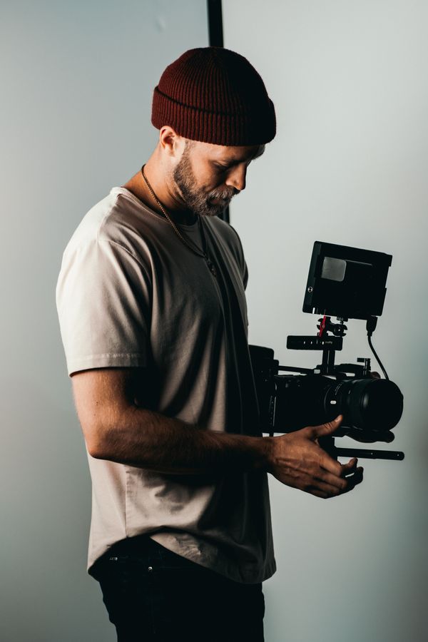 A camera operator holding a video camera in a studio