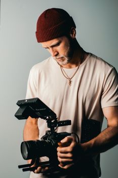 Photographer in a studio setting holding a professional camera. Focused and creative.