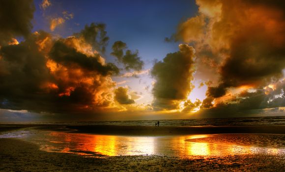 Capture of a vibrant sunset with dramatic clouds and reflections over ocean waves.