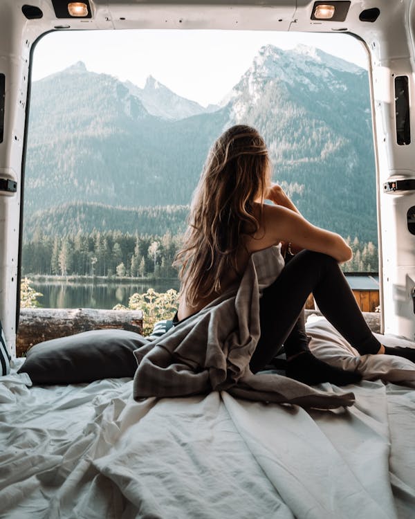 Free Woman in the Back of a Van Looking at Mountains Stock Photo