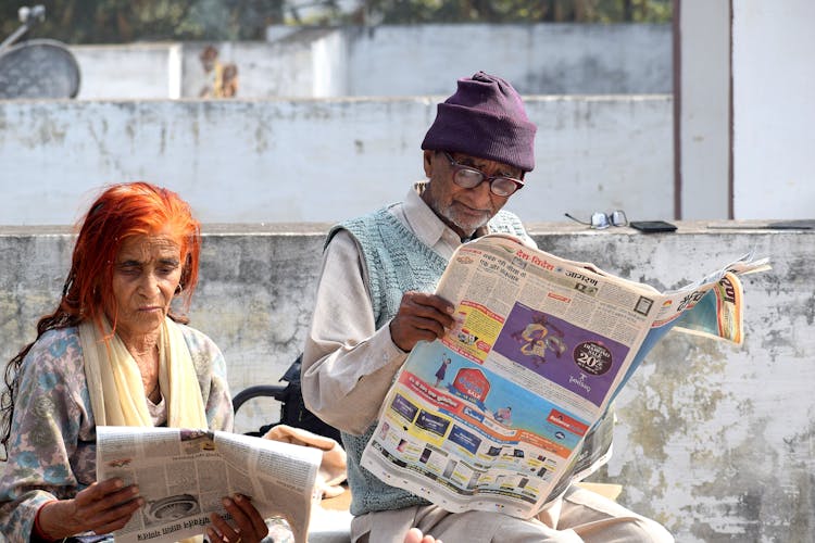 Man And Woman Reading Newspapers