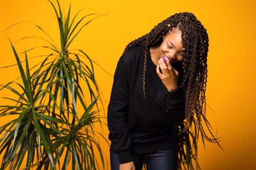 Gratis Optimista Joven Mujer Negra Divirtiéndose En Estudio Amarillo Foto de stock
