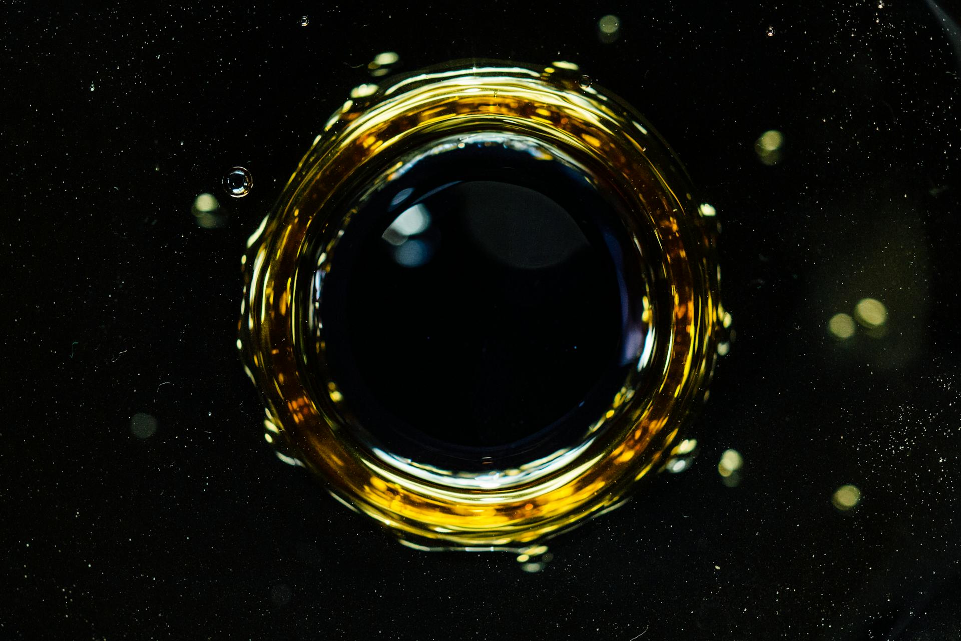 Background of macro drop falling into dark liquid and forming circle and bubbles on surface