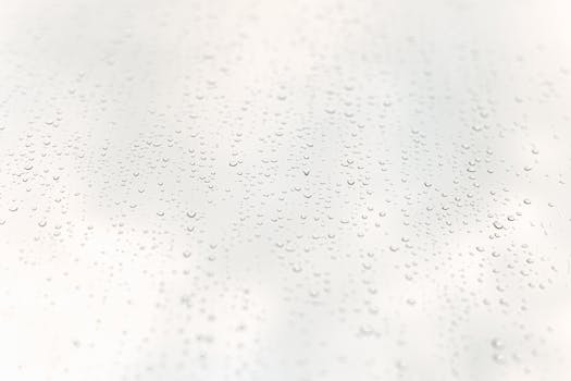Minimalist close-up of raindrops on a transparent window surface.