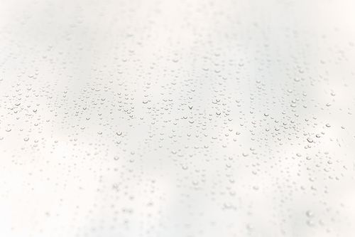Free Tiny transparent oval glistening drops on surface of window after rain in sunlight Stock Photo