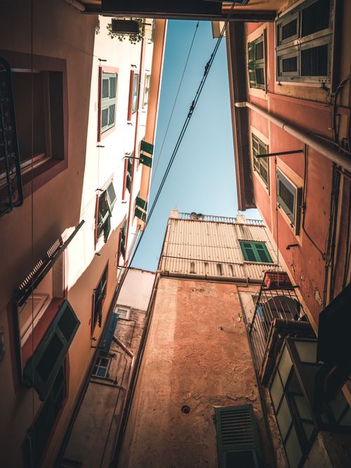 Free Low angle view of narrow alleyway in Riomaggiore, Italy, showcasing vibrant buildings under a clear blue sky. Stock Photo