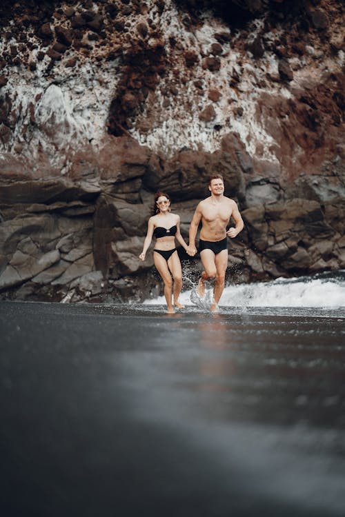 Happy couple running along seashn water