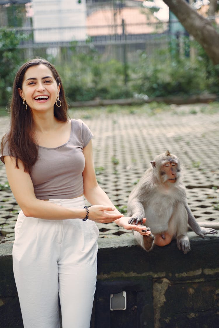 Laughing Woman Showing On Monkey In Park