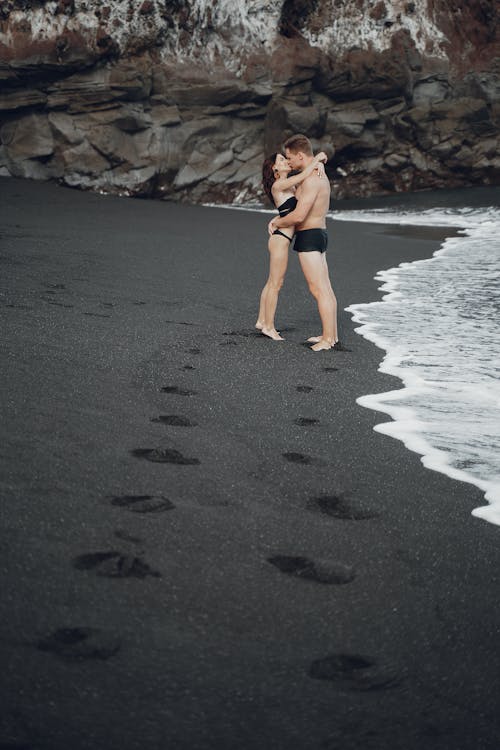 Young couple kissing on sand coast