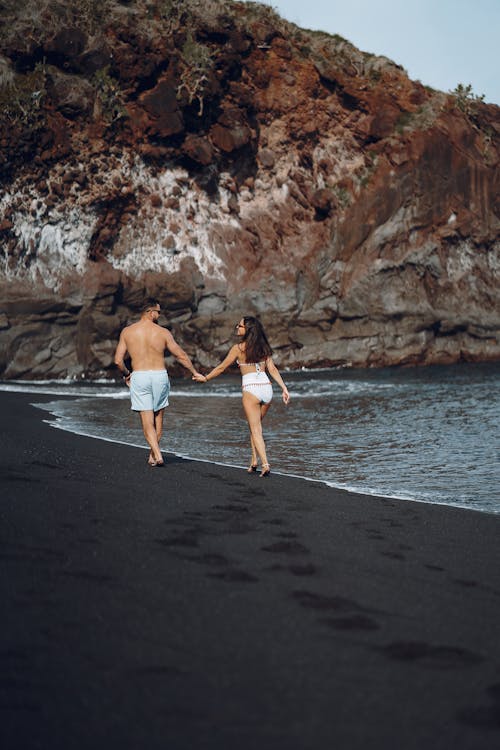 Young couple walking on sandy beach